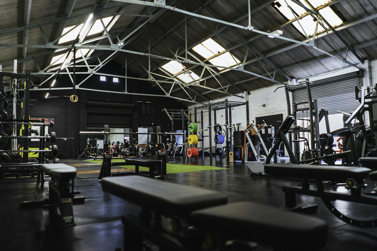 Open CrossFit gym floor with benches and rigs